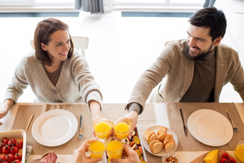 Coppia sorridente a tavola che condivide un pasto sano, simbolo di benessere e intimità